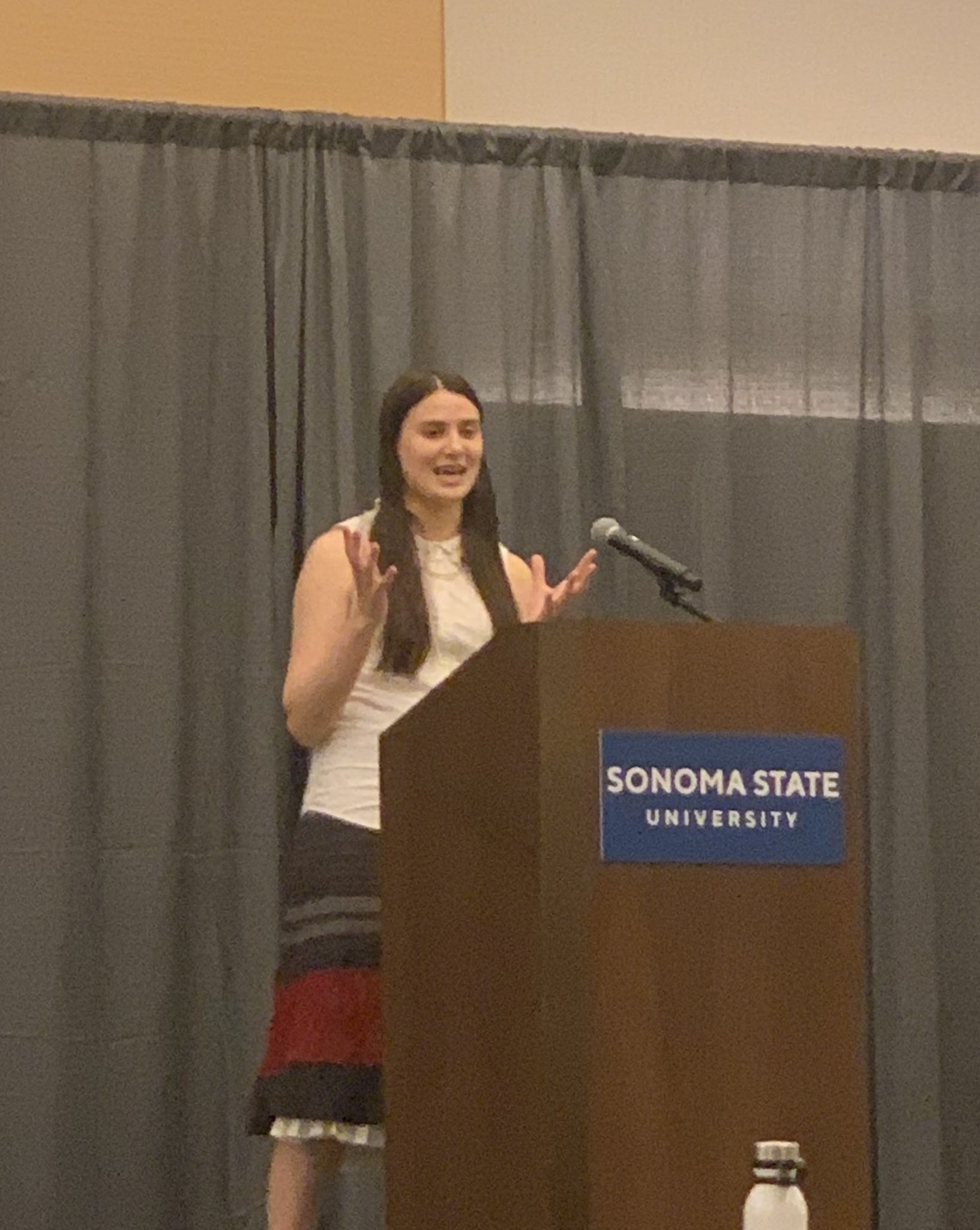 Student at podium smiling at audience