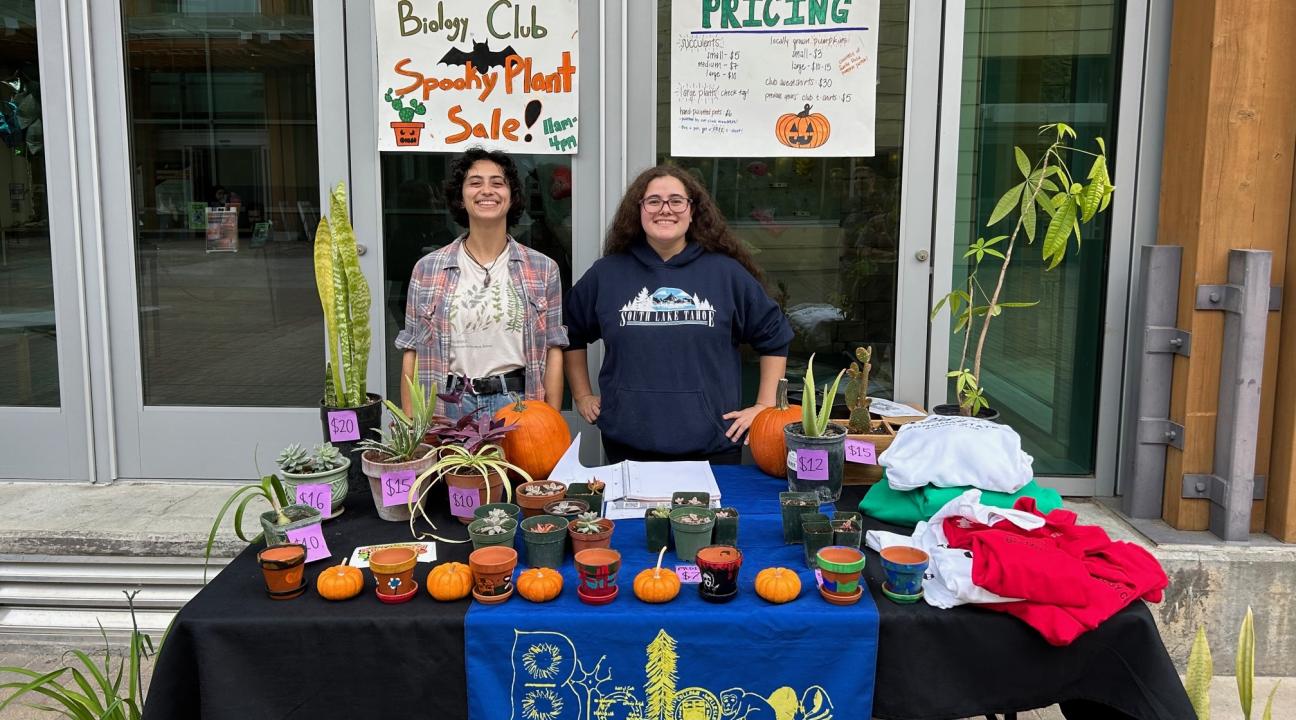 Students at a Table with plants and other items for sale