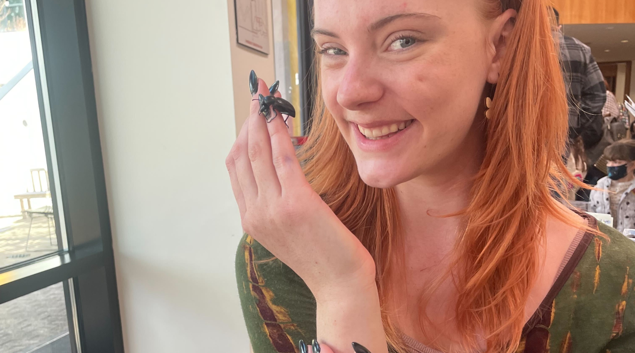 Student holding a beetle