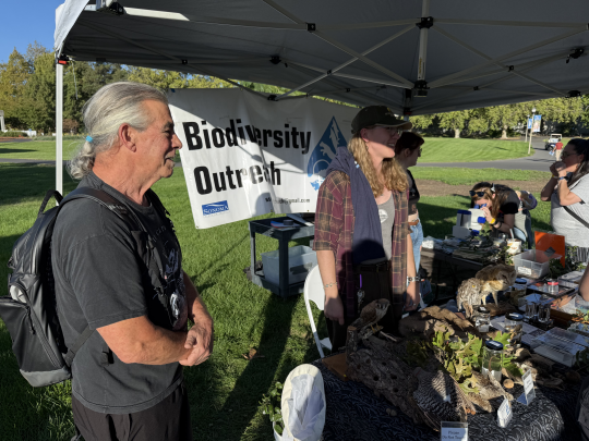 Professor and students tabling at promotional event