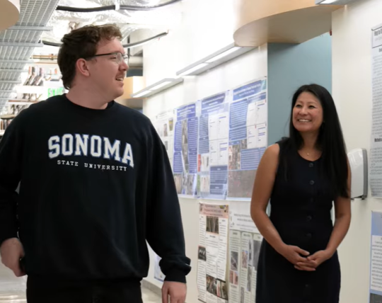 Kieran and Dr. Hua talking while walking down the hall in Darwin