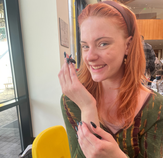 Student holding a beetle