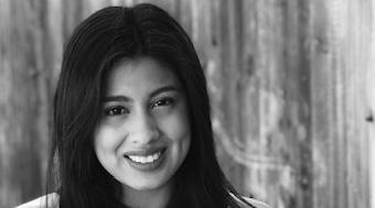  Jem Morales' black and white headshot in front of a wooden background.